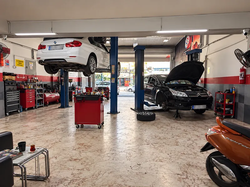 Liftte BMW ve bakımdaki araçlarla geniş atölye görünümü
